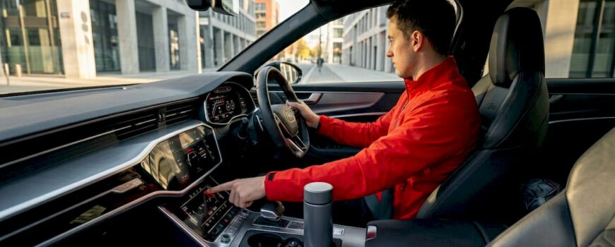 Driver activating sportback exhaust mode in car