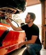 Enthusiast inspects car exhaust upgrade