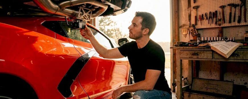 Enthusiast inspects car exhaust upgrade