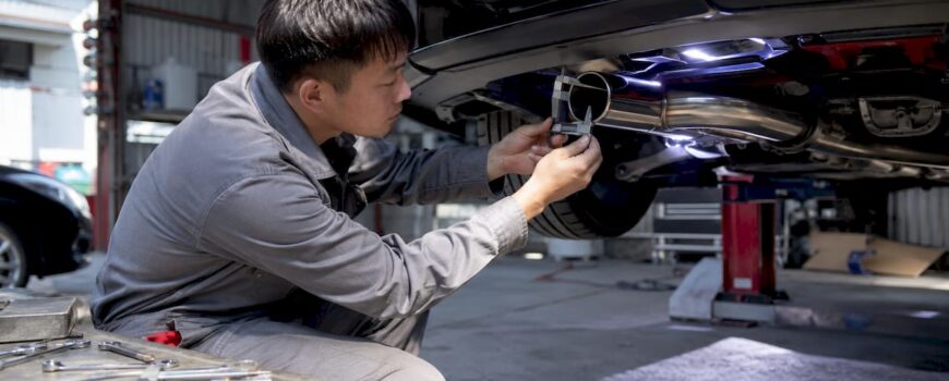 Mechanic measuring exhaust tip diameter