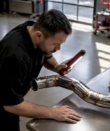 Technician inspecting turbo exhaust in workshop