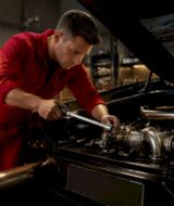Technician adjusting Lamborghini exhaust valve in workshop