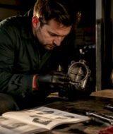 Mechanic inspecting exhaust butterfly valve in workshop