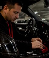 Man adjusting luxury car exhaust control inside vehicle