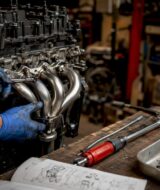 Mechanic installing exhaust manifold on engine