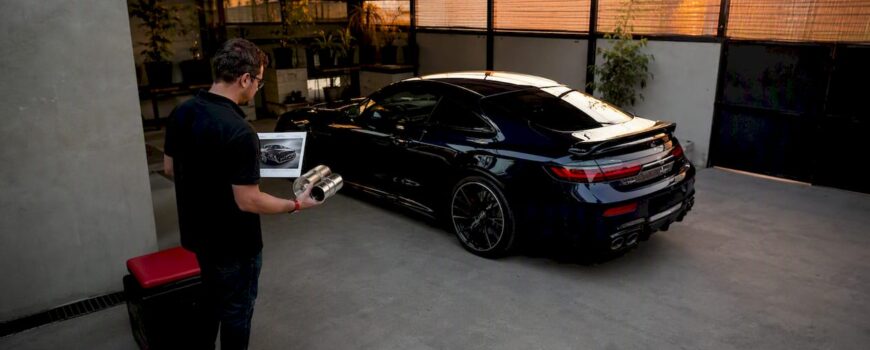 Man reviewing luxury car exhaust options in garage