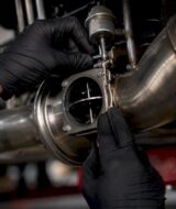 Technician adjusting valved exhaust component
