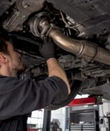 Mechanic inspecting a turbo downpipe connection