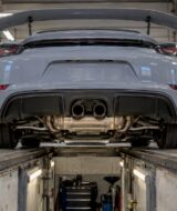 Cayman GT4 exhaust visible in inspection bay