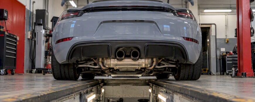 Cayman GT4 exhaust visible in inspection bay