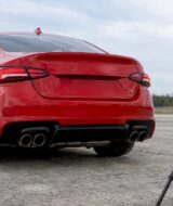 Red performance coupe beside exhaust sound meter